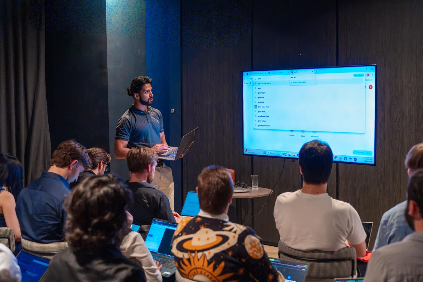 A student presenting in front of a screen to the room
