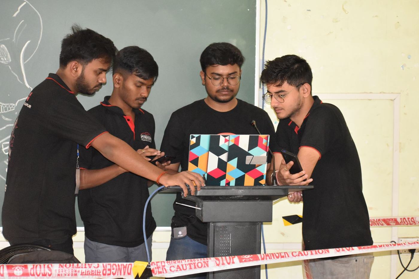 Four students building around a laptop